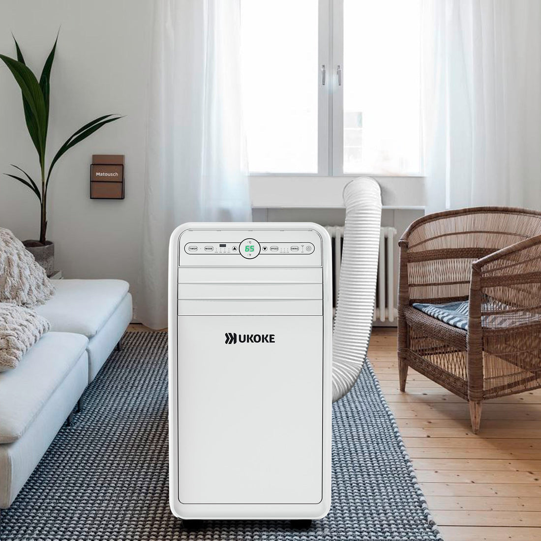 Portable air conditioner with vent hose in modern living room near window