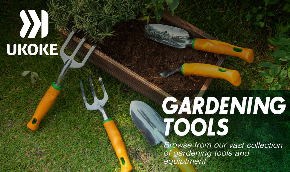 Hand gardening tools with orange handles and a small planter box on green grass.