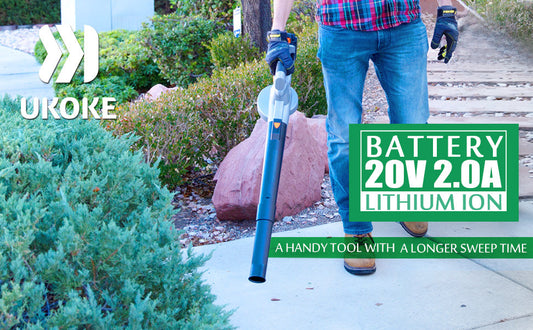 Man using cordless battery-powered leaf blower in garden landscaping setting