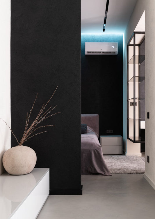 Modern bedroom with wall-mounted air conditioner, minimalist decor, and soft lighting